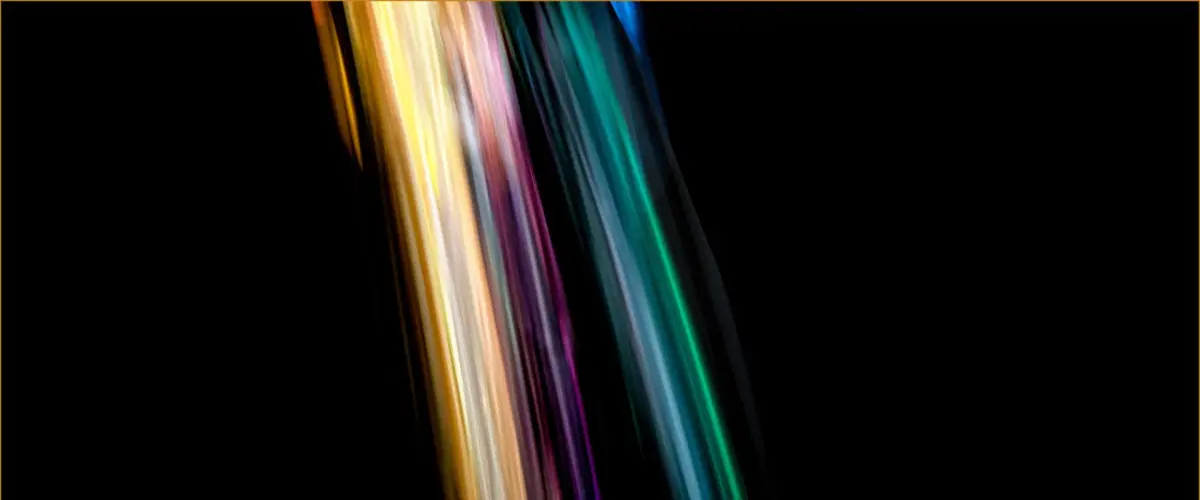 Colourful dice tumbling in streaks of light on a dark background